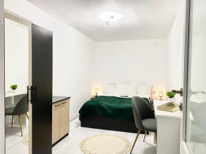 沃伊内亚萨Apartament - Voineasa的卧室配有一张床、一张桌子和椅子