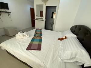 芭东海滩The Rich Patong的一张带两条毛巾和床边的床铺