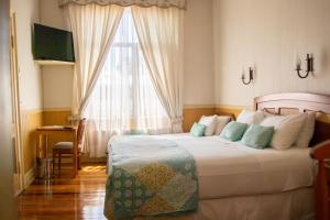 瓦尔迪维亚Hotel Di Torlaschi的一间卧室设有一张大床和一个窗户。