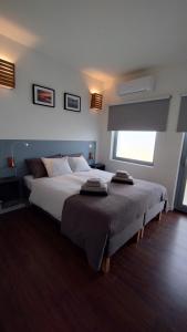圣卢西亚岛Casinha Secreta - A Gema Escondida da Santa Luzia的一间卧室设有一张大床和一个窗户。
