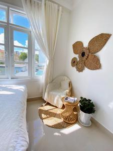 大叻Lantana Homestay的卧室配有床、椅子和窗户。