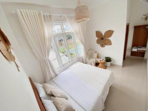 大叻Lantana Homestay的卧室配有白色的床和窗户。