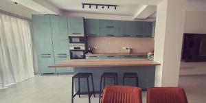 休吉让Mgarr ix-Xini Holiday apartment的厨房配有蓝色橱柜和带凳子的台面