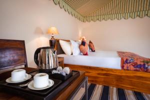 斋沙默尔Sonal Desert Camp Jaisalmer的一间卧室配有一张床和一张桌子及咖啡壶