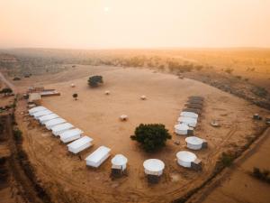 斋沙默尔Sonal Desert Camp Jaisalmer的一群白色的雨伞,放在泥土上