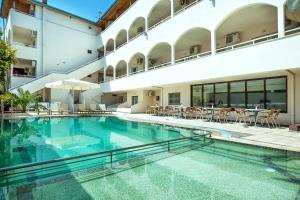 卡尼奥提Elinotel Polis Hotel的一座带桌椅的大型游泳池