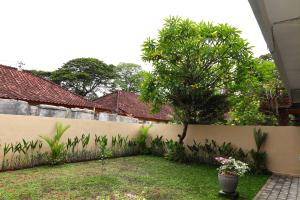 沙努尔Pondok Dete Guesthouse的后院,有栅栏和树