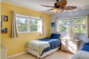 大松礁岛Big Pine Key Home on Bogie Channel with Dock and Slip!的一间卧室设有一张床和两个窗户。