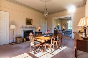 班敦Luxury country mansion in West Cork的一间带桌椅和壁炉的用餐室