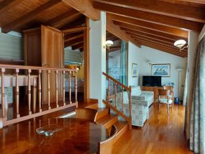 科雷焦Phi Hotel Dei Medaglioni的一间铺有木地板并设有一个楼梯的客厅