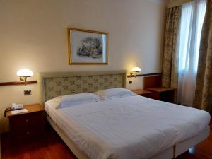 科雷焦Phi Hotel Dei Medaglioni的一间卧室配有一张大床和两盏灯。