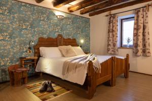 奥斯塔Chalet d'Aoste的一间卧室配有一张带花卉壁纸的木床