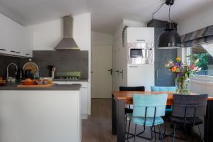 宁斯佩特Lodge Vlinder Nunspeet Veluwe的厨房配有木桌和蓝色椅子