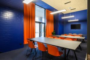 梅斯特CX Venice Mestre的一间会议室,配有桌子和橙色椅子