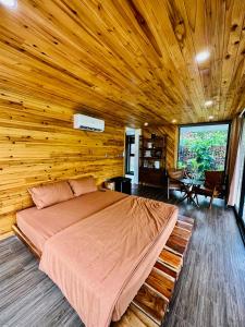 Sóc SơnSóc Sơn Homestay - Bird House的卧室配有木墙内的一张床