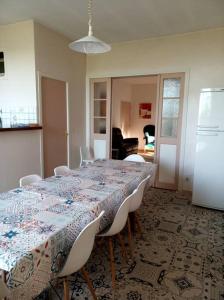 ViviersMaison familiale du Clos Saint Roch的一间带桌子和白色椅子的用餐室