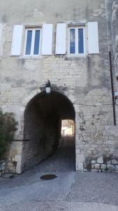 ViviersMaison familiale du Clos Saint Roch的一座石头建筑,有一条带窗户的隧道