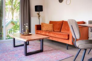 宁斯佩特Lodge Steltloper Nunspeet Veluwe的客厅配有橙色沙发和桌子