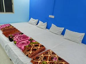 乌贾因M Baba Guest House的一张大床,放在鲜花盛开的房间