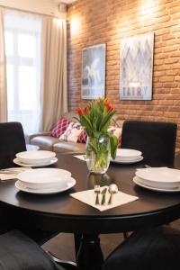 克拉科夫Lux apartmenty - Old City Kraków的餐桌,带盘子和花瓶