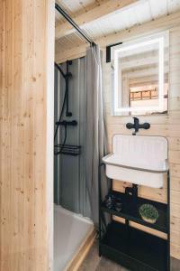 勒鲍Idyllisches Tiny House III mit Sauna的浴室配有盥洗盆和浴缸。