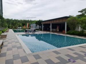 雪邦Luxury Tangerine Suites KLIA的一座带椅子的游泳池以及一座建筑