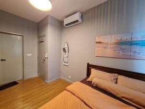 雪邦Luxury Tangerine Suites KLIA的卧室配有一张床,墙上挂有绘画作品