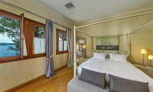 奈德里Villa Veneziano Suites & Villa的一间卧室配有一张床、一张沙发和窗户。