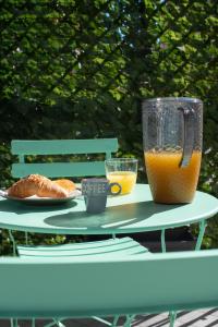 那不勒斯MarGab Guest House的一张桌子,上面放着一杯橙汁和羊角面包
