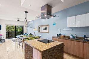 图卢姆Luxurious Penthouse with Jungle View & Private Pool的厨房以及带蓝色墙壁和柜台的起居室。