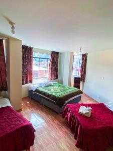 瓦拉斯Chacraraju Hostel的一间卧室配有两张红色床单