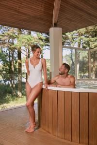圣让-德蒙Résidence Valdys Thalasso & Spa - les Pins的站在热水浴池中的男女