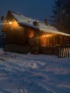 WojtkowaBieszczadzka Sielanka的雪覆盖的房屋,晚上有灯