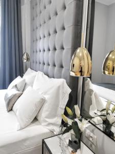 萨格勒布MINT Boutique Studio Apartments的卧室配有一张白色的床和大型床头板