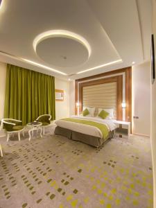 沙鲁拉HOTEL ALFAW PLAZA的一间卧室配有一张大床和绿帘