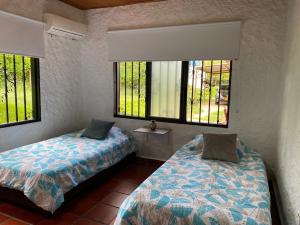 里韦拉Villa Zunilda的一间卧室设有两张床和两个窗户。