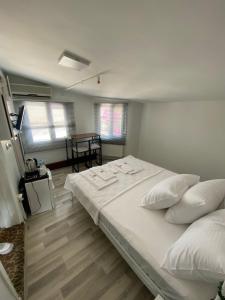 伊斯坦布尔Heybeliada Pansiyon的卧室配有一张带白色床单和枕头的大床。