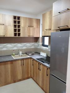 弗尔沙茨Apartman SARA的厨房配有木制橱柜和不锈钢冰箱。