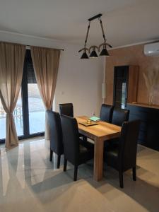 弗尔沙茨Apartman SARA的用餐室配有木桌和黑椅子