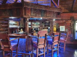 Sasolburg4 Fish Eagle Lodge的一间拥有木墙的用餐室和一间带椅子的酒吧