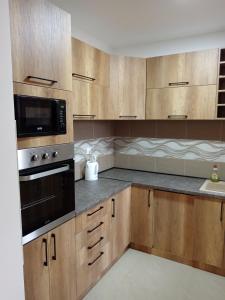 弗尔沙茨Apartman SARA的一间带木制橱柜和微波炉的厨房