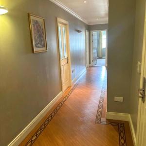 基拉尼Spacious 2 bedroom apartment in Killarney的空的走廊,铺着木地板,设有门
