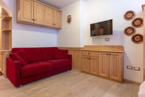 安达洛Bilo al Piccolo Gufo的客厅配有红色沙发和电视