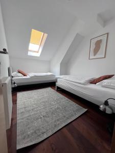 萨格勒布Cozy Loft Apartment in Zagreb Center的配有地毯的客房内的两张床