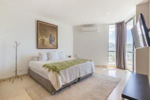 圣玛尔塔Grand Marina Suites Santa Marta的白色的卧室设有床和大窗户