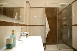 特拉尼DIMORE DEL SUD City Center的一间带玻璃淋浴和水槽的浴室