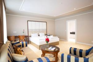 施库尔Scuol Palace Bed & Breakfast的酒店客房带一张床、一张桌子和椅子
