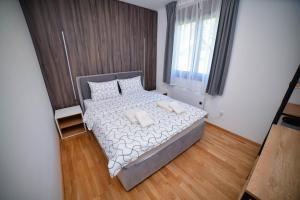 兹拉蒂博尔Zlatibor Breza Apartment and Spa的小卧室配有带白色床单和枕头的床