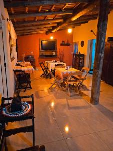 瓦尔任博尼塔Canto do Rio Pousada的配有桌椅和电视的房间