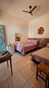 瓦尔任博尼塔Canto do Rio Pousada的一间卧室配有两张床和吊扇